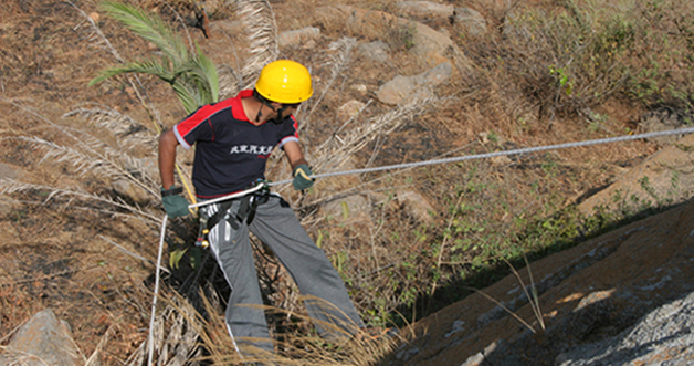 Guide rappelling down a rock face at Kunti Betta