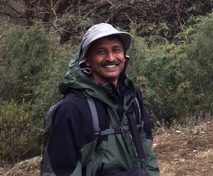 Ganesh smiling during a trek in a forest